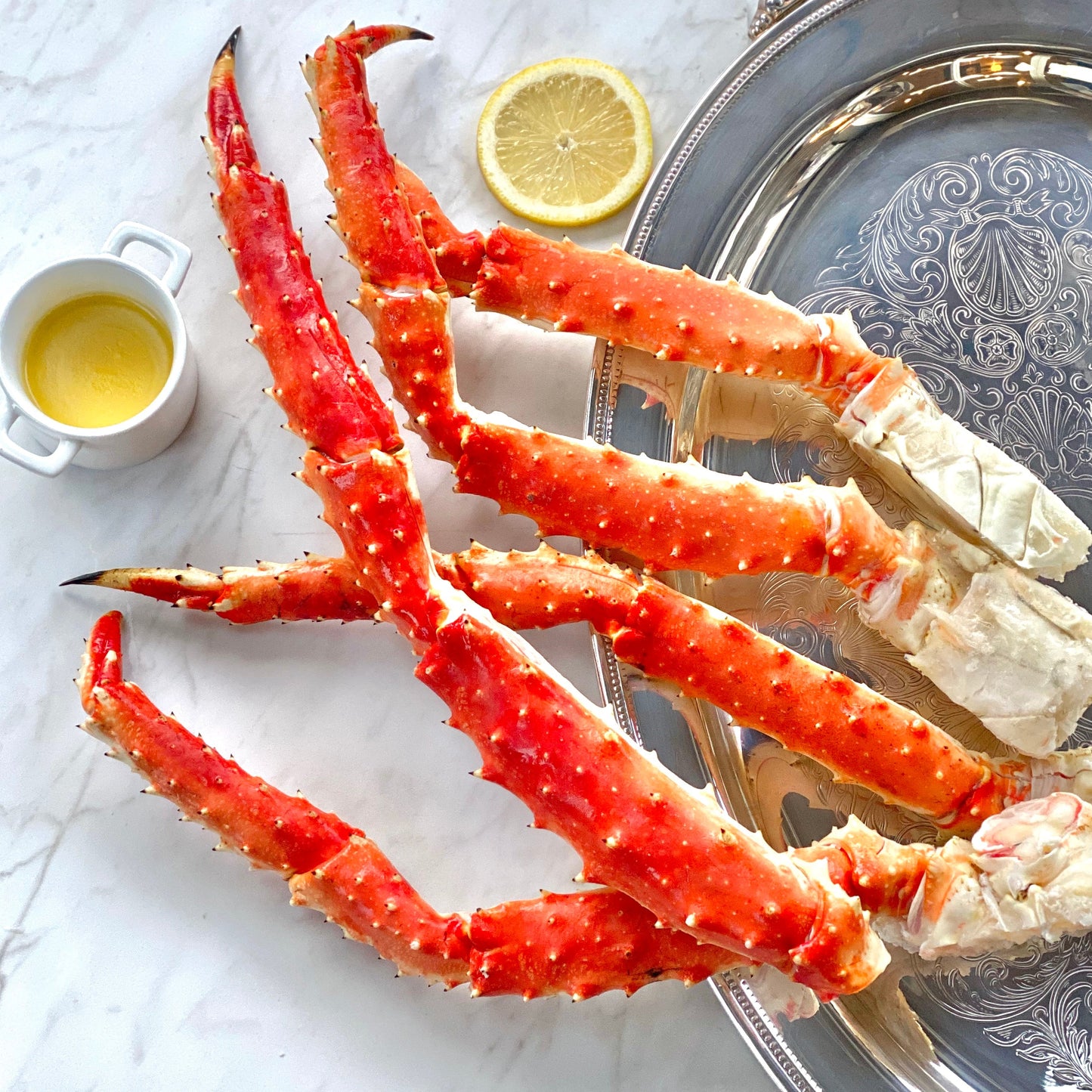 Wild Alaskan red king crab legs arranged on a platter with lemon slices