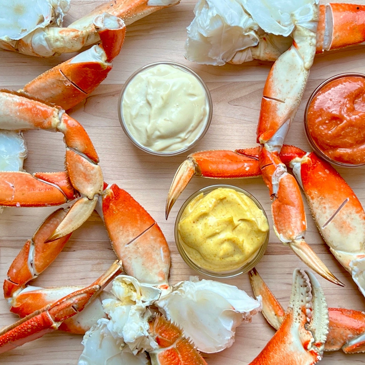 Wild Alaskan Dungeness crab legs arranged with dipping sauces