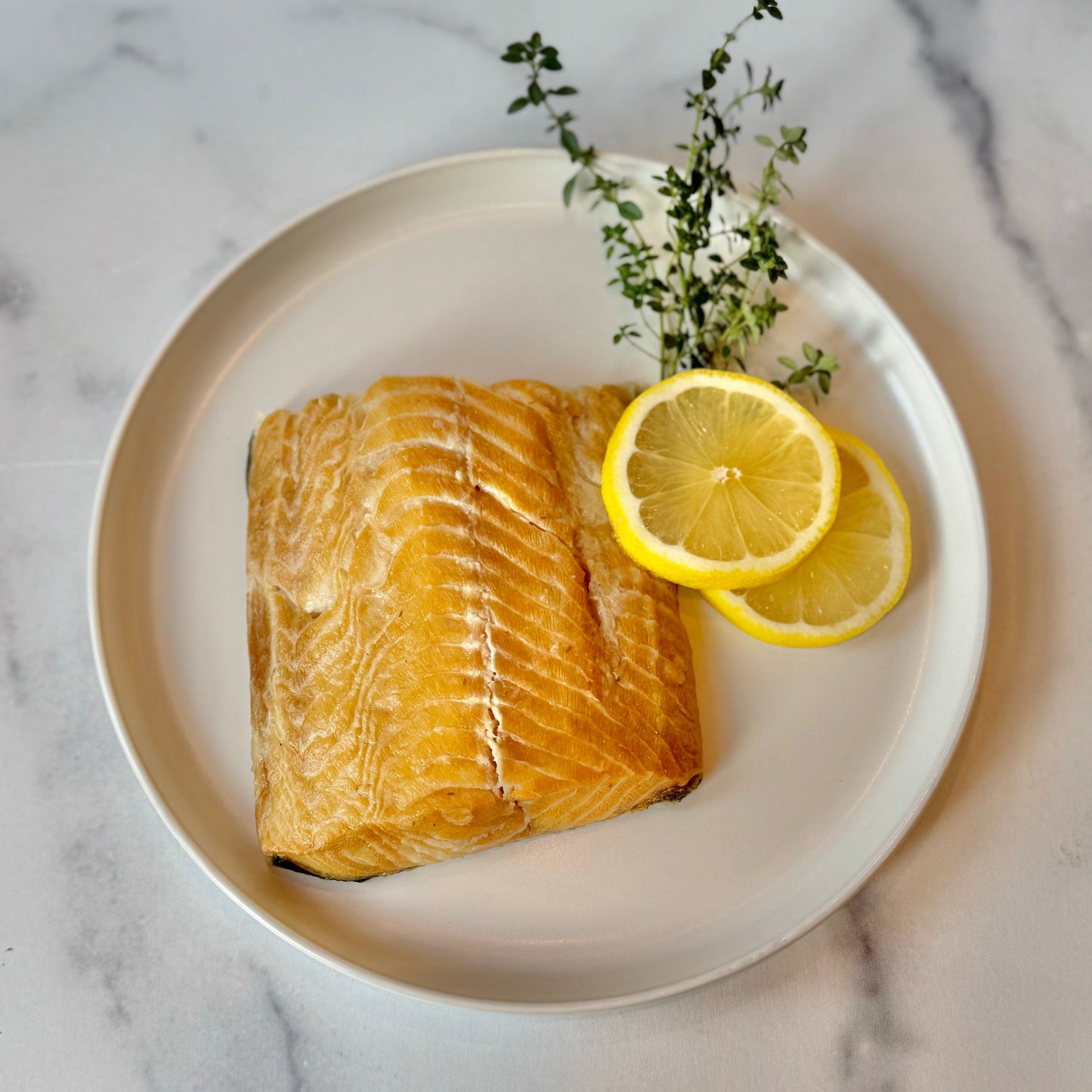 Wild Alaska smoked sablefish fillet plated with lemon slices