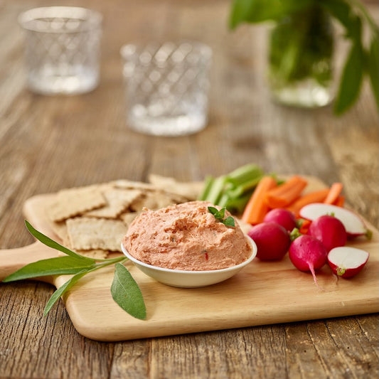 Smoked salmon dip with crackers, radishes, and vegetables on a serving board, made with wild Alaskan salmon.
