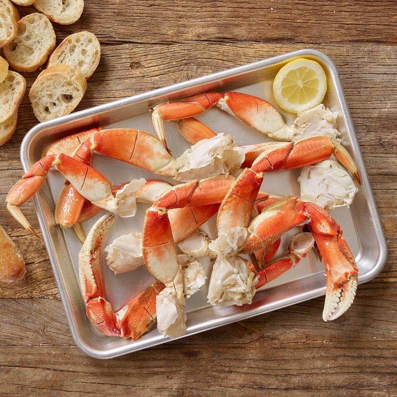 Wild Alaskan Dungeness crab legs on a tray with lemon slices