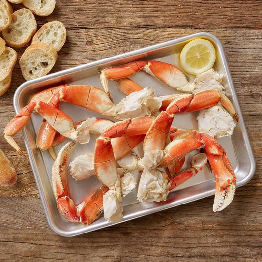 Wild Alaskan Dungeness crab legs on a tray with lemon slices