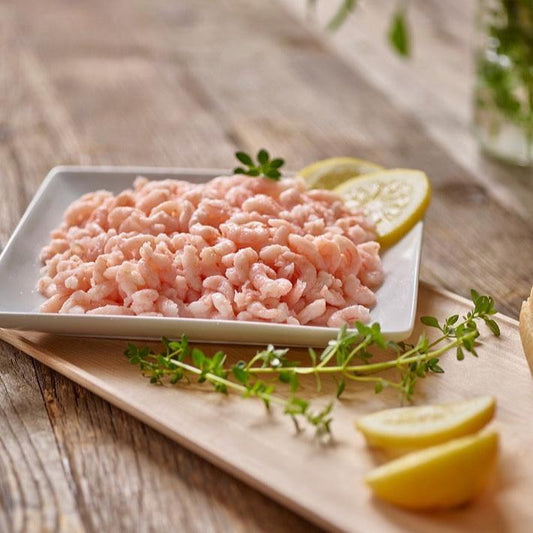 Wild Oregon shrimp in a bowl with lemon wedges and fresh herbs