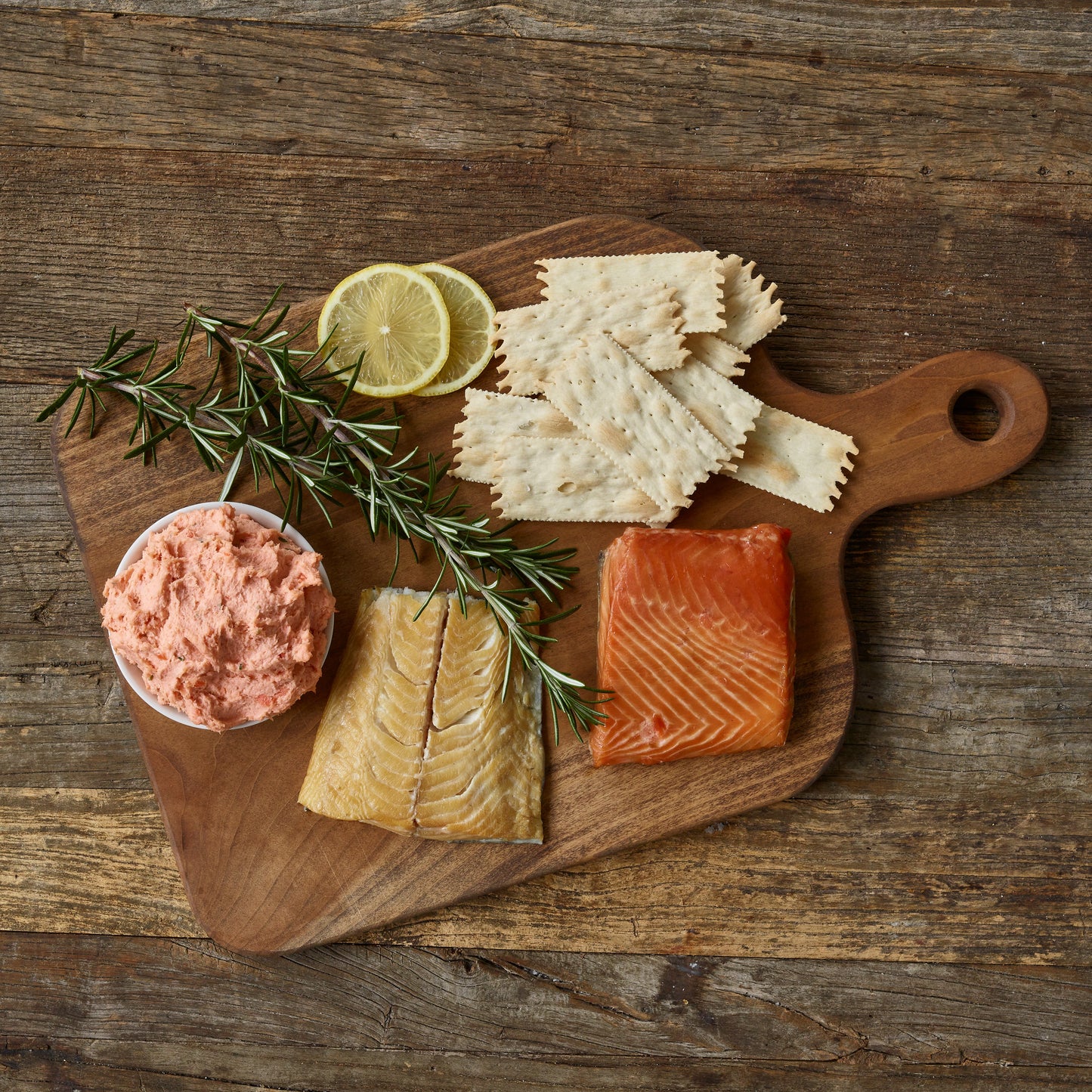 Wild Alaska smoked sablefish served on a seafood board with smoked salmon, smoked salmon dip, crackers, and lemon